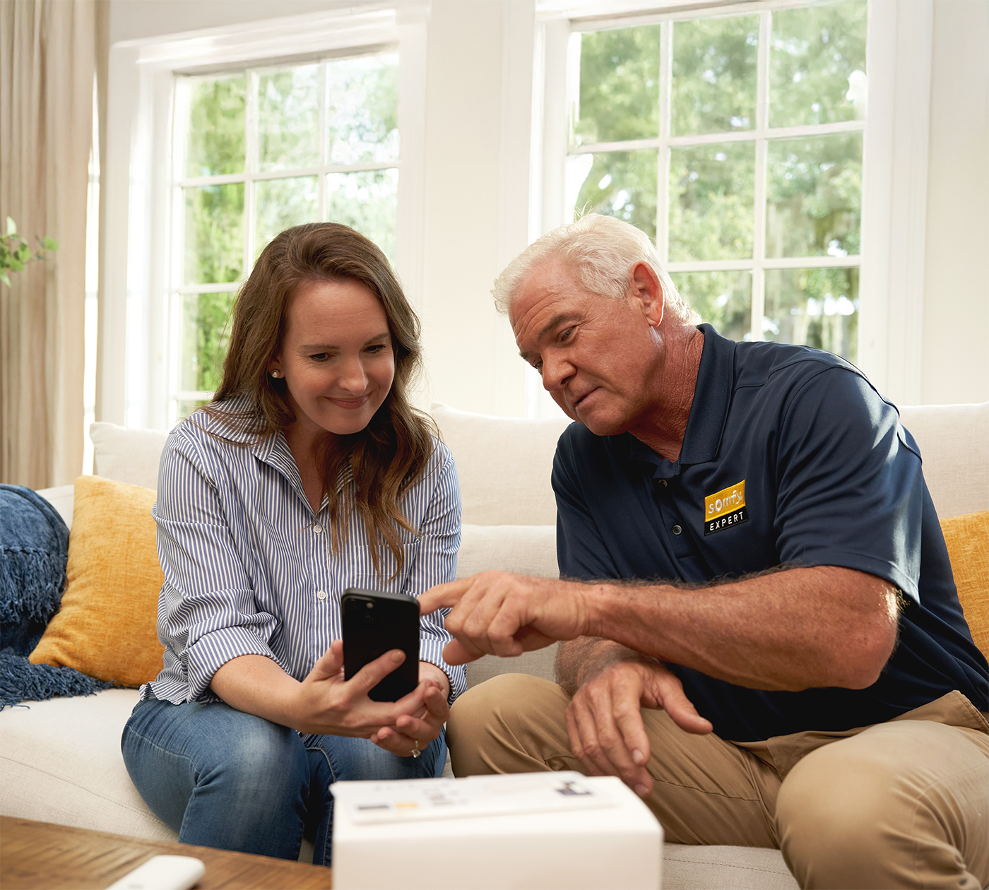 Woman and a Somfy Dealer setting up newly installed shades through the app.