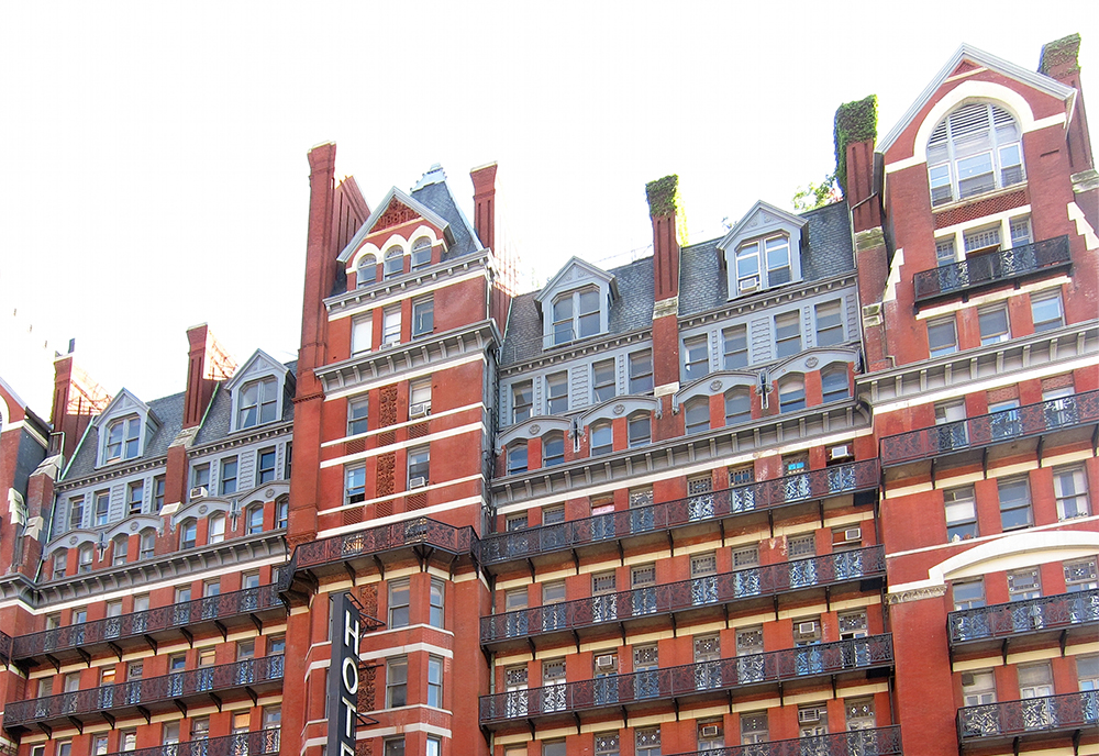 Closeup of The Hotel Chelsea highlighting the red brick exterior and many balconies.