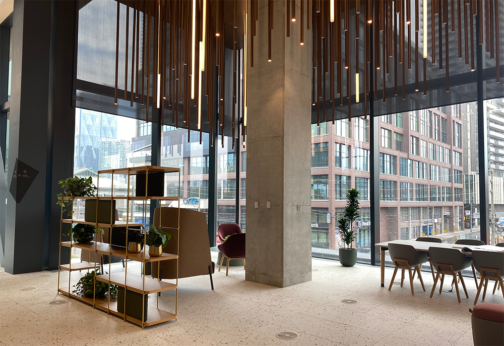 Alternative angle of the Waterfront Innovation Center showing a sitting area with chairs overlooking another building straight ahead.