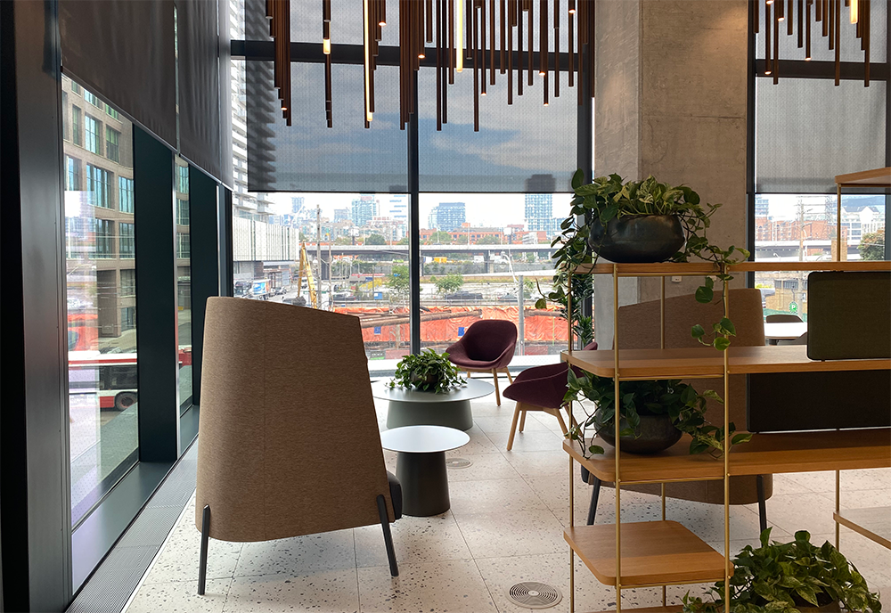 Interior image of the Waterfront Innovation center with three chairs in the foreground overlooking a construction site.