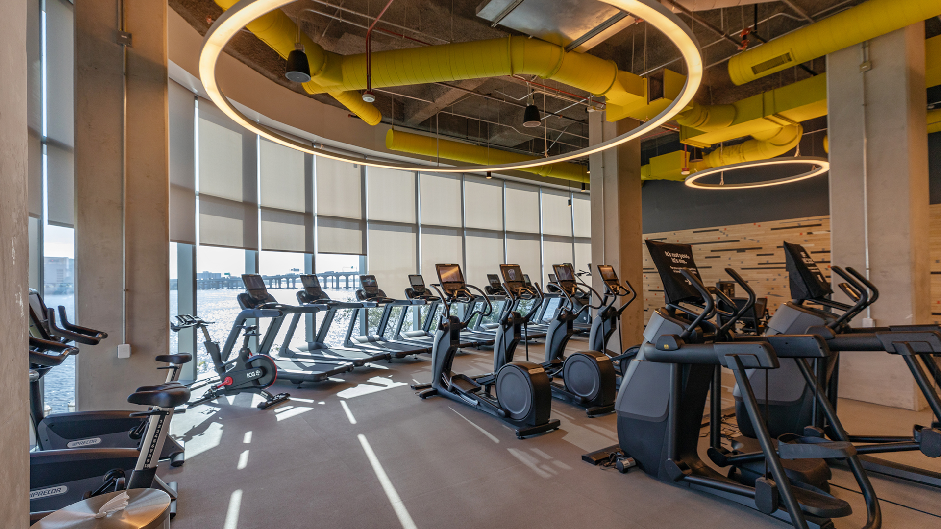 Fidelity employee gym with rows of elyptical machines and treadmills looking out of tall windows.