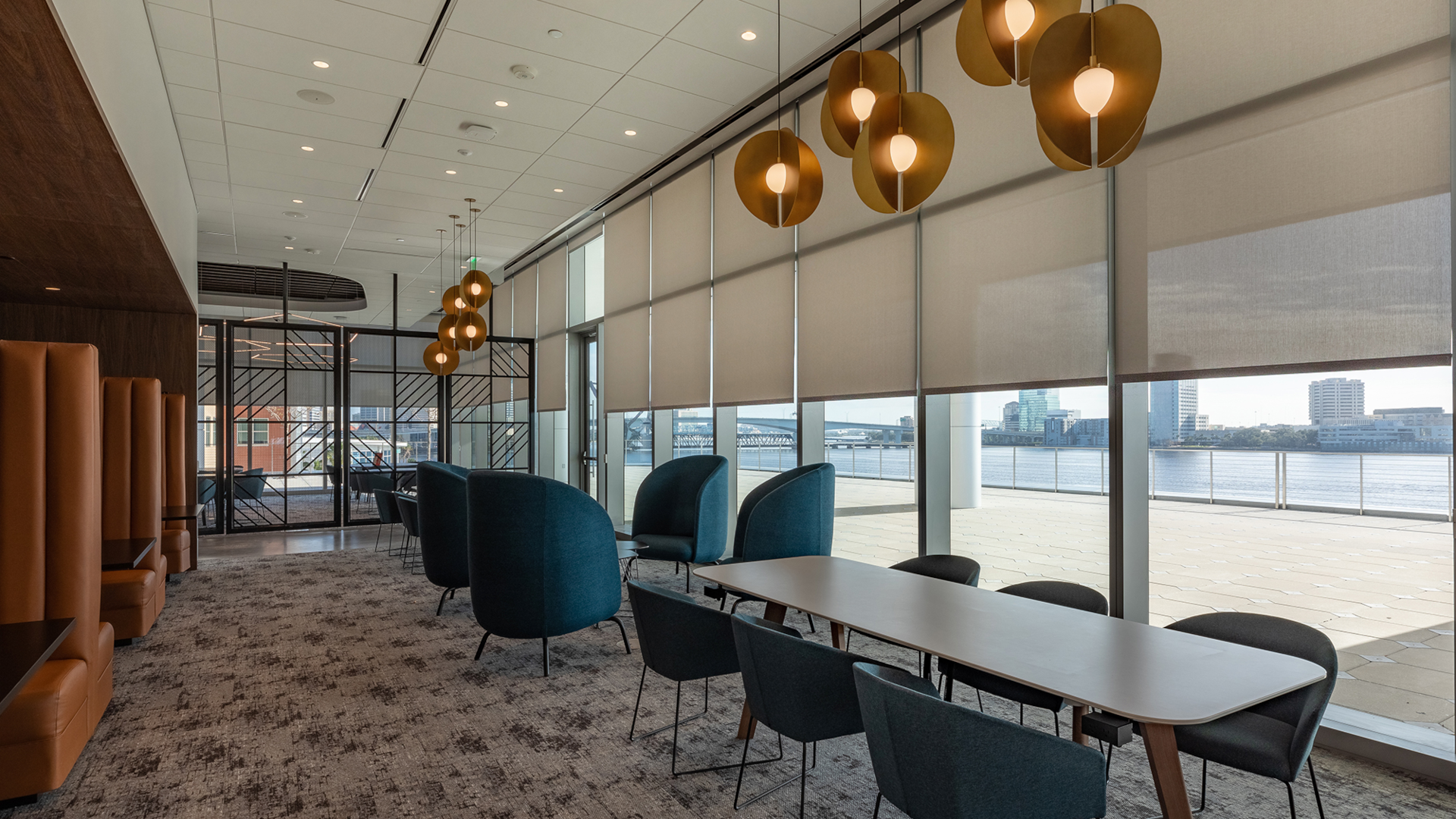 Fidelity Investment Services dining and lounge area with subdued natural lighting as shades are half lowered over the tall windows.